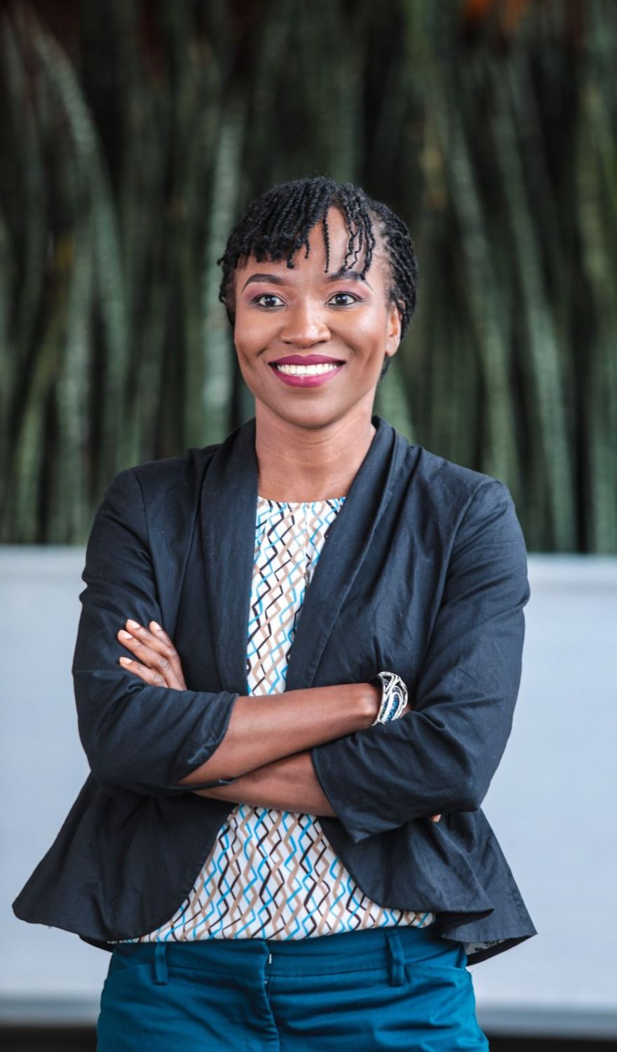 Diana Ayoo smiling with her arms crossed